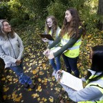 Edmonds resident Ruth Blaikie talks with Edmonds-Woodway High School students Malia Clark, Klyr Oines and Ava Wilson about salmon she sees coming through Shell Creek in her back yard. (Ian Terry / The Herald)