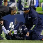 Seahawks free safety Earl Thomas (29) is examined by team physician Dr. Ed Khalfayan (left) after injuring his leg in the first half of a game against the Panthers this past Sunday in Seattle. (AP Photo/Ted S. Warren)