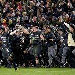 Army players and coaches run onto the field after defeating Navy 21-17 in a game Saturday in Baltimore. (AP Photo/Patrick Semansky)