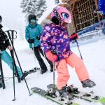 Isabelle Youn tries on her father&rsquo;s skis on Wednesday at Stevens Pass Ski Resort as parents Andrew Carlson (left) and Susan Chong watch. (Kevin Clark / The Herald)