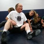 Rick Iversen demonstrates a maneuver as he coaches the Everett girls wrestling team during practice on Wednesday. (Andy Bronson/The Herald)