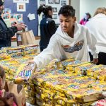 Gavin Clements distributes snacks as part of the Advent Lutheran Church holiday Food Baskets Program in Mill Creek on Dec. 16, 2016. Volunteers provided holiday meals with frozen turkeys to 225 families in south Snohomish County. (Bill Trueit / For the Herald)