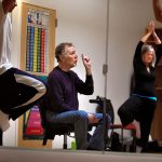 From a seat on an electric scooter, and with wife Diane Brooks nearby, Paul MacNaughton leads a yoga class at Everett Community College on April 25, 2013. MacNaughton died Dec. 16 following a long battle with bone cancer. (Dan Bates / The Herald)
