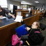 LeeAndra Nagel (right), of Everett, delivers mail around the Snohomish county campus on Nov. 10. Nagel has worked at the county since 2000. (Ian Terry / The Herald)