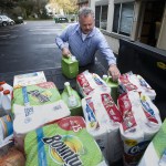 Sandy Biggs unloads cleaning supplies from the back of his truck that he donated to the YWCA Pathways for Women shelter in Lynnwood on Nov. 23. (Ian Terry / The Herald)