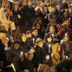 A crowd holds candles during a vigil in memory of victims of a warehouse fire at Lake Merritt on Monday, Dec. 5, in Oakland, California. Family members and friends are being notified as firefighters continue a painstaking search for victims of the Oakland warehouse fire. (AP Photo/Marcio Jose Sanchez)