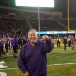 Longtime Huskies fan Sam Watkins flashes his ring on the field after a victory against Oregon this year. The commemorative gold ring was given to 25 people whose name were drawn from the group who have been season ticket holders since 1991. (Courtesy Sam Watkins)
