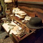 A desk in the &ldquo;study&rdquo; of Dr. Arthur Conan Doyle is crowded with research and notes. (Christina Okeson / The Herald)