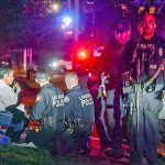 Police stand by a distraught Kristi Croskey at the scene where a Tacoma Police officer Reginald &ldquo;Jake&rdquo; Gutierrez was shot while responding to a domestic call in east Tacoma. (Peter Haley/The News Tribune via AP)