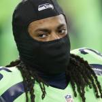 Seahawks cornerback Richard Sherman wears a mask to stay warm as he stretches before a game against the Rams on Dec. 15 in Seattle. (AP Photo/Scott Eklund)