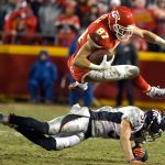 Chiefs tight end Travis Kelce (87) leaps over Broncos safety Justin Simmons (31) during the second half of a game Sunday in Kansas City, Mo. (AP Photo/Ed Zurga)