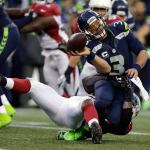 Seahawks quarterback Russell Wilson (3) is tackled by the Cardinals&rsquo; Sio Moore as he releases the ball in the second half of a game Saturday in Seattle. (AP Photo/John Froschauer)