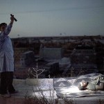 A man points a flashlight towards the body of a Syrian man killed by Syrian army shelling at a graveyard in Aleppo, Syria, on Oct. 13, 2012. (AP Photo/Manu Brabo, File)