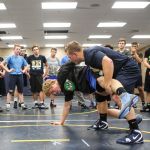 New Arlington wrestling coach Jonny Gilbertson demonstrates a take down on Gavin Rork during practice Wednesday.(Kevin Clark/The Herald)