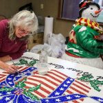 Claudia Pollock retouches decorations at Warm Beach Lights of Christmas on November. (Kevin Clark / The Herald)