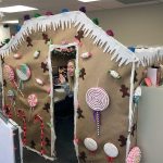 Insurance Services Group employee Marie Boughton peeks out from her gingerbread house. The Christmas cubicle contest was part of a festive season at the Edmonds company, which also collected gift cards for Washington Kids in Transition. (Contributed photo)