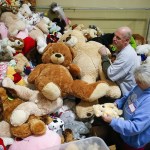 Volunteers David May and Bette Hawkins pile up stuffed animals during the annual Christmas House holiday gift giveaway in Everett on Friday, Dec. 2. (Ian Terry / The Herald)