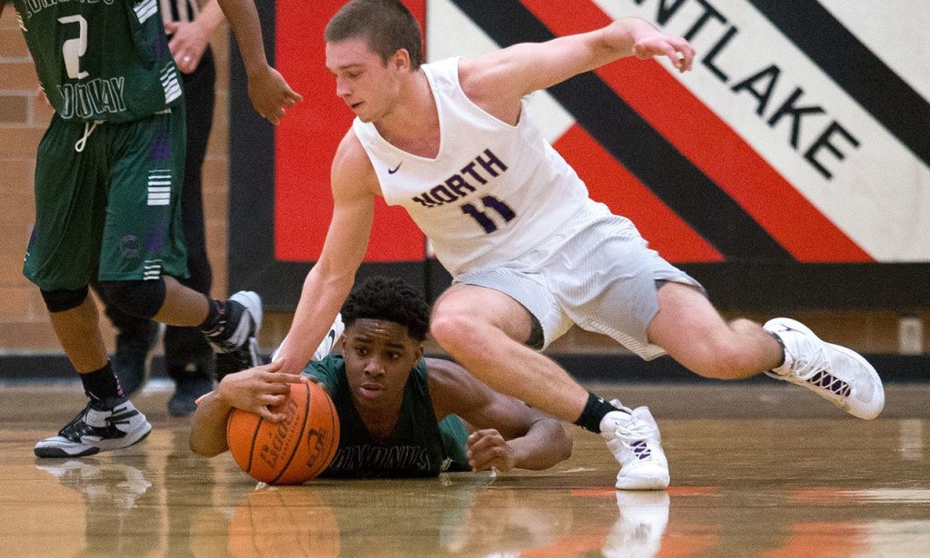 Edmonds-Woodway&rsquo;s Uchenna Acholonu grabs the loose ball as North Kitsap&rsquo;s Jake Houghton reaches down as Edmonds-Woodway lost to North Kitsap 68-62 at the 2016 Mountlake Terrace Boys Varsity Basketball Tournament on Tuesday, Dec. 27, 2016 in Mountlake Terrace, Wa. (Andy Bronson / The Herald)