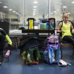 Kayla Black, 10, and her brother, Kamden, 13, lace up their skates prior to training at Olympic View Arena in Mountlake Terrace on Dec. 15. (Ian Terry / The Herald)