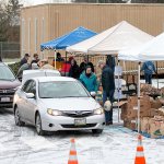 Volunteers load up on food items to deliver to families in need around the Mill Creek and south Everett area. Cars lined up behind the church and waited to stop at three loading stations where bags of food, milk and frozen turkeys were provided. (Bill Trueit / For the Herald)