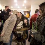 Sandy Flores, in white hat, hugs Sandi Olson, who made her a keys holder from items found in the previous home as they celebrate the Flores&rsquo; new home from Habitat for Humanity of Snohomish County on Saturday in Everett. The Flores and their three young children became the new owners of Phoenix II, a house in North Everett, to which they contributed more than 500 hours of sweat equity. (Andy Bronson / The Herald)