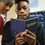 Seventh-grader Marquirus Jennings (right) looks at the &ldquo;Passport to Manhood&rdquo; booklet, which will be in his care for the next year. Looking on is fellow seventh-grader Montez Young. (Andy Bronson / The Herald)                                Seventh grader Marquirus Jennings (right) looks at the Passport to Manhood booklet, which will be in his care for the next year, after the &ldquo;Passport to Manhood&rdquo; program graduation at Voyager Middle School on Tuesday, Nov. 29, in Everett. Looking on is fellow seventh grader Montez Young. (Andy Bronson / The Herald)