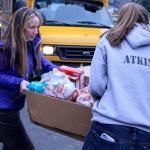 Granite Falls High School staff member Jackie Woolman-Morgan and Food Drive Coordinator Lindsey Atkinson load food and gifts in vehicles for personal delivery to families. (Contributed photo)