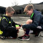 Colby Johnson (left) is helped by Shoelace Brigade member Josh Delap at Penny Creek Elementary School. (Contributed photo)