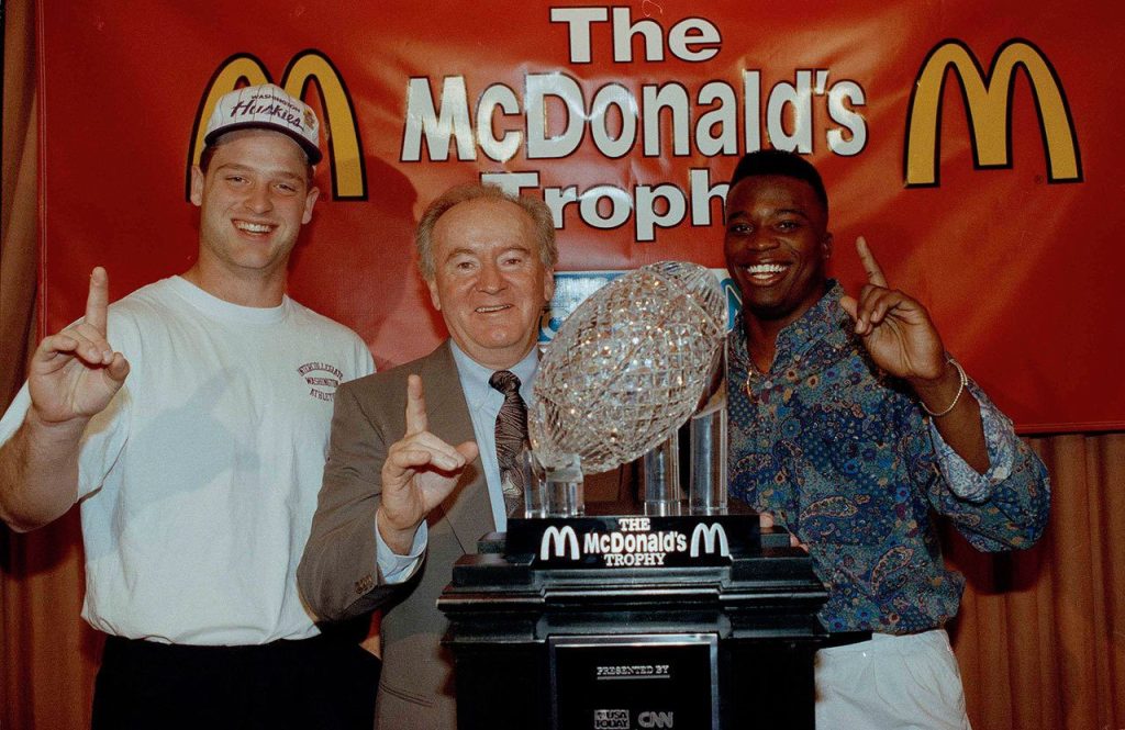 University of Washington coach Don James (center), quarterback Billy Joe Hobert (left) and running back Beno Bryant accept the McDonald&rsquo;s Trophy on Jan. 2, 1992 in Anaheim, Calif. After beating Michigan in the Rose Bowl 34-14, the Huskies were chosen No.1 in the USA Today-CNN coaches poll, but sportswriters picked Miami as the national champion in the AP poll. (AP Photo/Nick Ut)