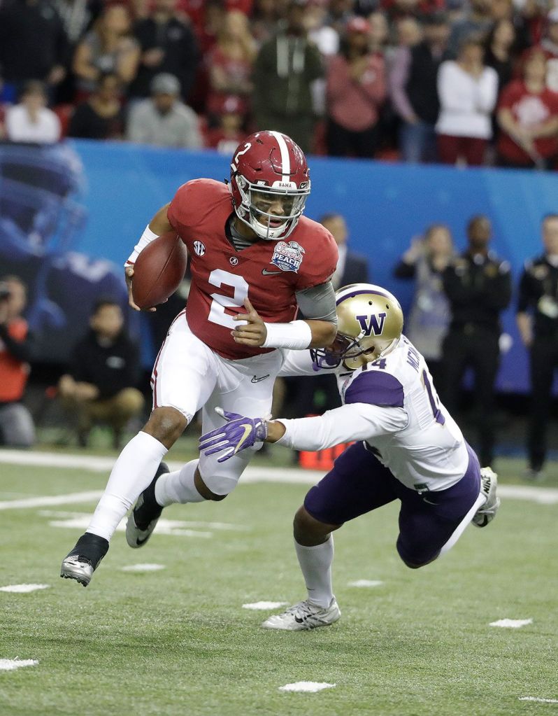 Alabama quarterback Jalen Hurts (2) is tackled by Washington defensive back Jojo McIntosh (14) during the first half of the Peach Bowl on Saturday in Atlanta. (AP Photo/David Goldman)