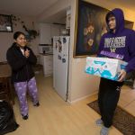 Rosa Garcia smiles as Cascade High senior Briar Nguyen carries in one of several boxes of food for the family as students, alumni and volunteers gather and deliver food from Cascade High School on Wednesday, Dec. 14, 2016 in Everett, Wa. (Andy Bronson / The Herald)