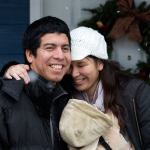 Ray and Sandy Flores hug on their front porch after accepting the keys to their new home from Habitat for Humanity of Snohomish County on Saturday in Everett. (Andy Bronson / The Herald)