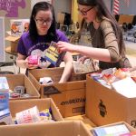Food Drive Coordinator Isabella Hensley receives help from student Breanna Wilkerson while packing food boxes for local families. (Contributed photo)