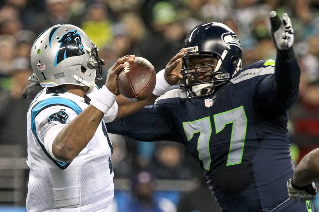 Panthers quarterback Cam Newton attempts to avoid a pass rush by Seahawks defensive lineman Ahtyba Rubin Sunday night at CenturyLink Field in Seattle on December 4, 2016.(Kevin Clark / The Herald)