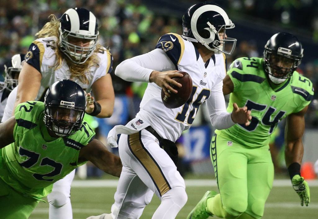 Rams quarterback Jared Goff attempts to escape a pass rush by Seahawks defensive lineman Michael Bennett, left, and Seahawks linebacker Bobby Wagner at CenturyLink Field Thursday night in Seattle on December 15, 2016. (Kevin Clark / The Herald)