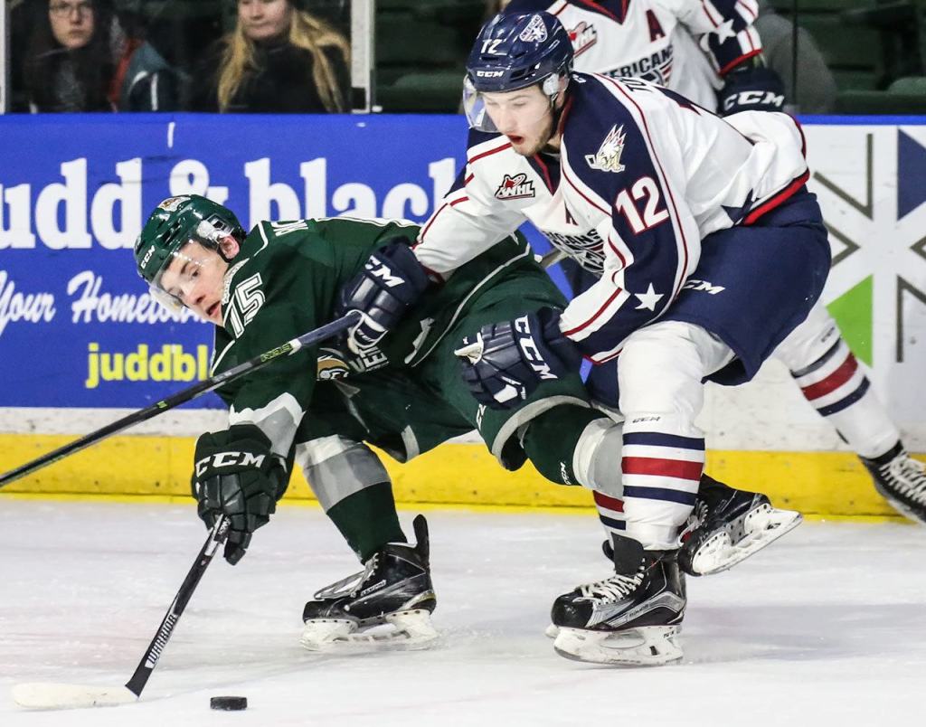 The Silvertips&rsquo; Sean Richards (left) attempts to control the puck with the Americans&rsquo; Jordan Topping defending Wednesday night at Xfinity Arena in Everett. (Kevin Clark / The Herald)