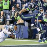 Seahawks running back Thomas Rawls leaps a tackle attempt by Panthers corner back Daryl Worley for a touchdown Sunday night at CenturyLink Field in Seattle on December 4, 2016.(Kevin Clark / The Herald)