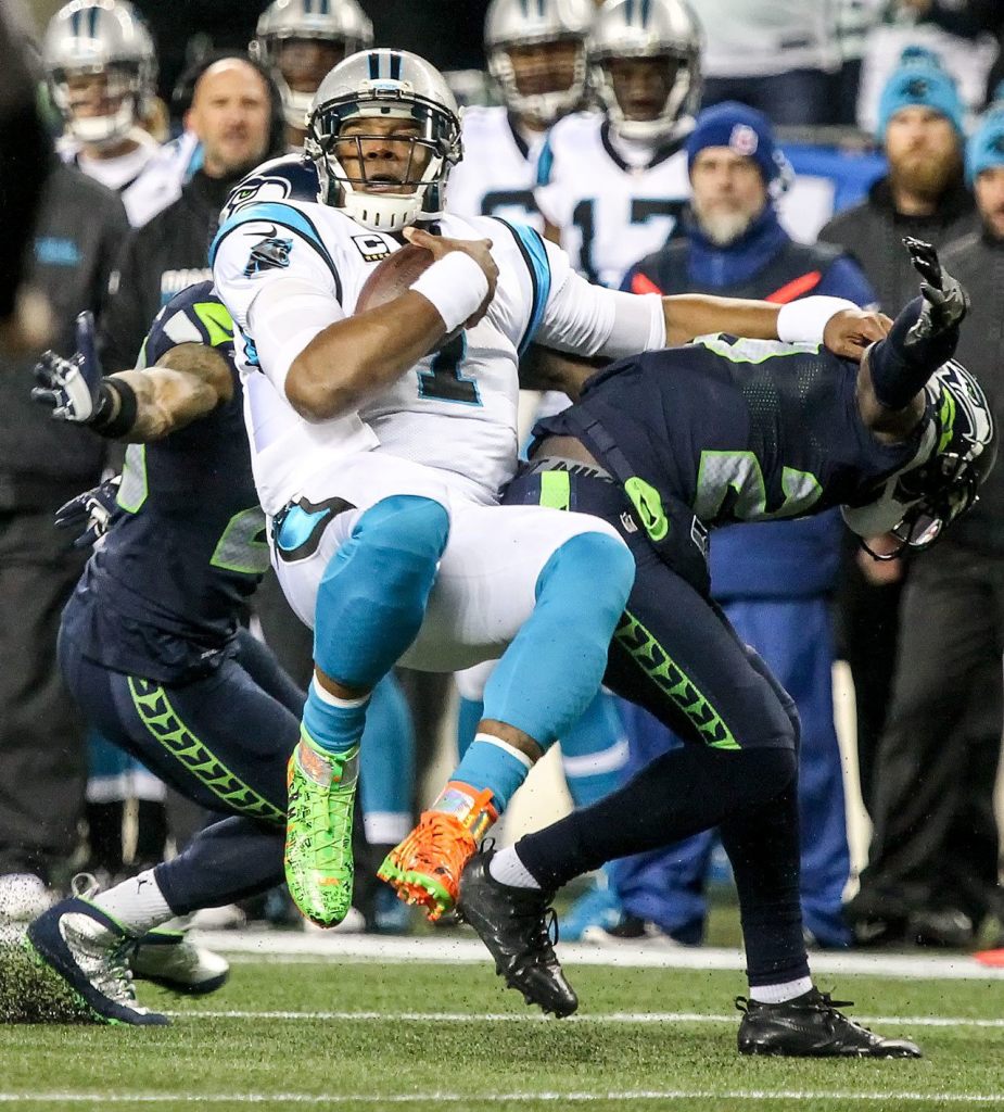 Panthers quarterback Cam Newton is tackled by Seahawks corner back Jeremy Lane Sunday night at CenturyLink Field in Seattle on December 4, 2016.(Kevin Clark / The Herald)