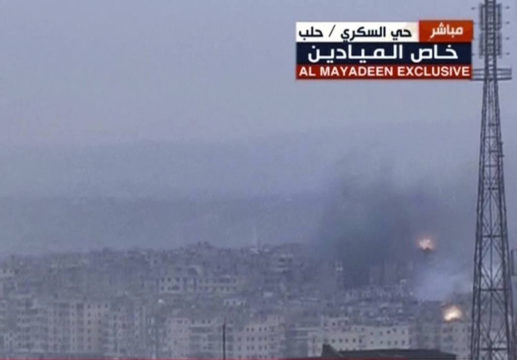 This frame grab from video provided by the Beirut-based pan-Arab satellite channel Al Mayadeen, which is close to the Syrian government, broadcast on Wednesday, Dec. 14, shows explosions followed by plumes of smoke, in East Aleppo, Syria. (Al Mayadeen TV, via AP)
