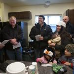 Pastor Ken Long holds an electric candle as he blesses the new house from Habitat for Humanity of Snohomish County for Ray and Sandy Flores (center) on Saturday. The previous house on the site burned down in 2014, and Long didn&rsquo;t want to use &rdquo;real fire&rdquo; in the new home. (Andy Bronson / The Herald)