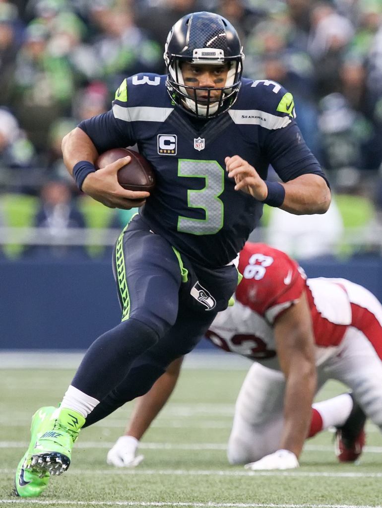 Seahawks quarterback Russell Wilson strambles for yargage against Saturday afternoon at CenturyLink Field in Seattle on December 24, 2016. The Cardinals won 34-31. (Kevin Clark / The Herald)