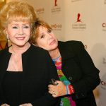 In this Aug. 19, 2003 photo, Debbie Reynolds and Carrie Fisher arrive at the &ldquo;Runway for Life&rdquo; Celebrity Fashion Show Benefitting St. Jude&rsquo;s Children&rsquo;s Research Hospital and celebrating the DVD relese of Chicago in Beverly Hills, California. (AP Photo/Jill Connelly, File)