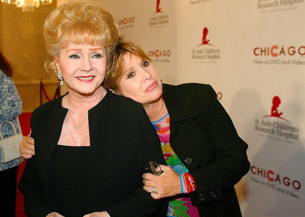 In this Aug. 19, 2003 photo, Debbie Reynolds and Carrie Fisher arrive at the &ldquo;Runway for Life&rdquo; Celebrity Fashion Show Benefitting St. Jude&rsquo;s Children&rsquo;s Research Hospital and celebrating the DVD relese of Chicago in Beverly Hills, California. (AP Photo/Jill Connelly, File)
