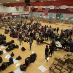 A gym full of students, alumni and volunteers gather and deliver food from Cascade High School on Wednesday, Dec. 14, 2016 in Everett, Wa. (Andy Bronson / The Herald)