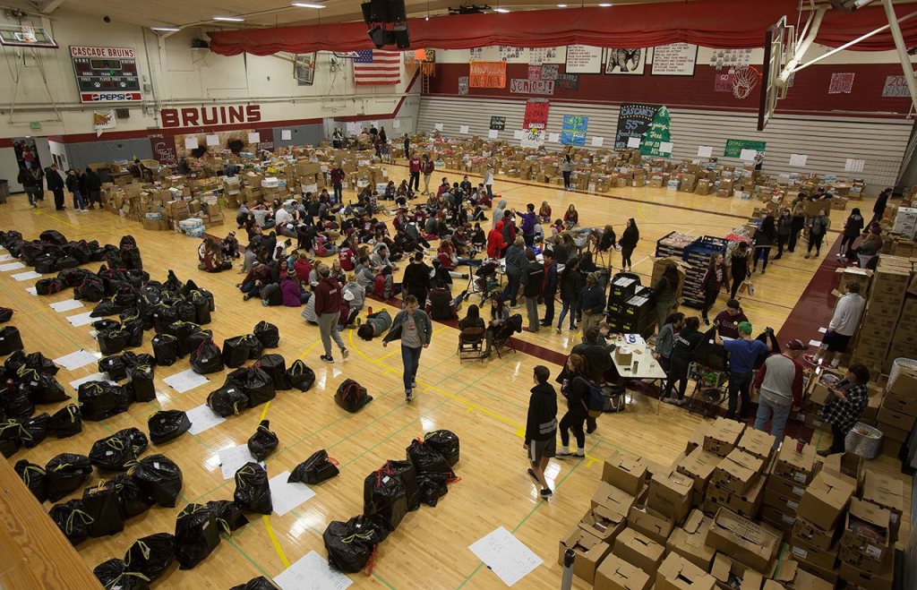 A gym full of students, alumni and volunteers gather and deliver food from Cascade High School on Wednesday, Dec. 14, 2016 in Everett, Wa. (Andy Bronson / The Herald)