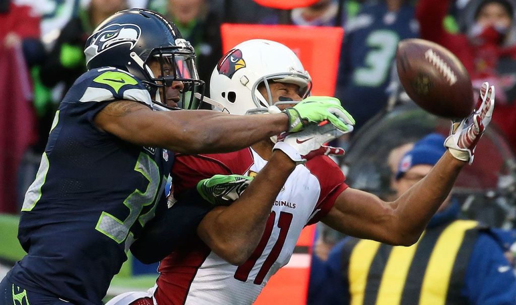 Cardinals wide receiver Larry Fitzgerald makes a reception with Seahawks player DeShawn Shead defending Saturday afternoon at CenturyLink Field in Seattle on December 24, 2016. The Cardinals won 34-31. (Kevin Clark / The Herald)