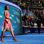 First lady Michelle Obama, dressed in a Tracy Reese pink silk jaquard dress, walks on the stage at the Democratic National Convention in Charlotte, North Carolina, in 2012. (AP Photo/Jae C. Hong, File)