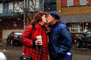 After lunching together at The Sisters Restaurant in Everett, Terry Tavares, 73, and his wife, Linda Guy-Tavares, 66, walk outside and cheerfully discover it has begun to snow. Linda has to go to work, but not without a kiss from Terry. &ldquo;She&rsquo;s my child-bride,&rdquo; he says, after she drives off. (Dan Bates / The Herald)