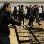 Students line up to get addresses before gathering and delivering food from Cascade High School on Wednesday, Dec. 14, 2016 in Everett, Wa. (Andy Bronson / The Herald)