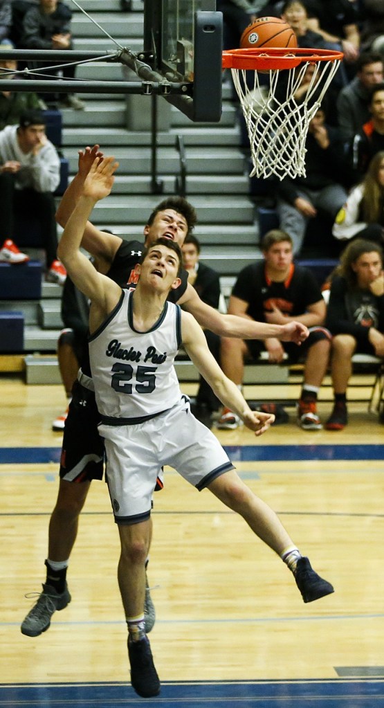 Glacier Peak&rsquo;s Noah Forman (25) goes up for a shot as Monroe&rsquo;s Spencer Davidson defends during a game at Glacier Peak High School on Tuesday. Glacier Peak beat Monroe 56-46. (Ian Terry / The Herald)